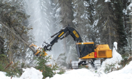 Excavator in snow and forest clearing trees